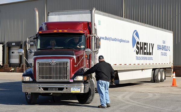Student practicing backing truck into a warehouse dock.
